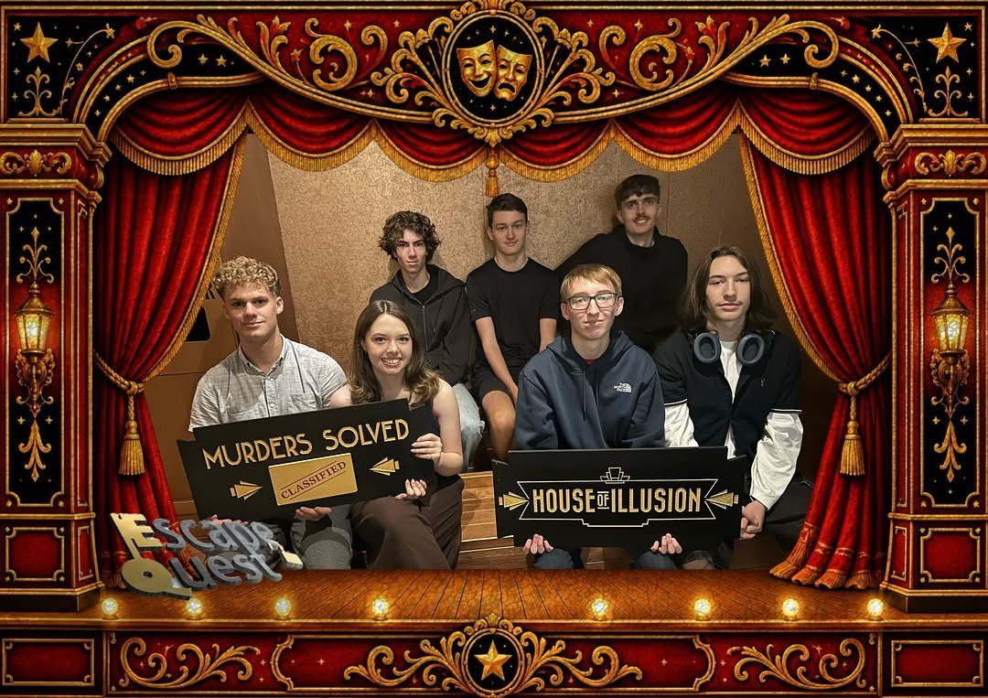 Group of young adults posing with signs after completing an escape room challenge.