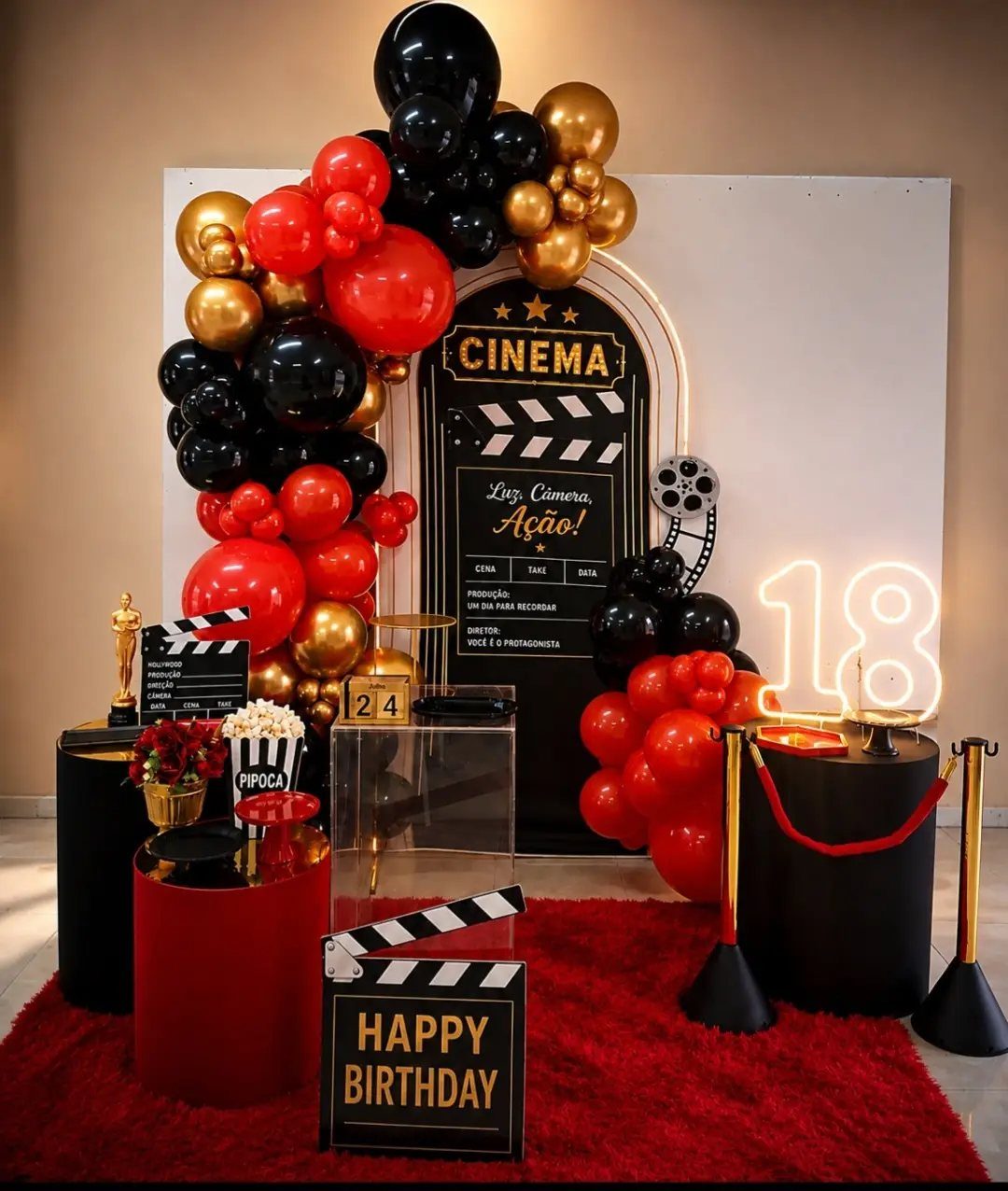 Cinema-themed 18th birthday party setup with red carpet, balloons, and movie props.