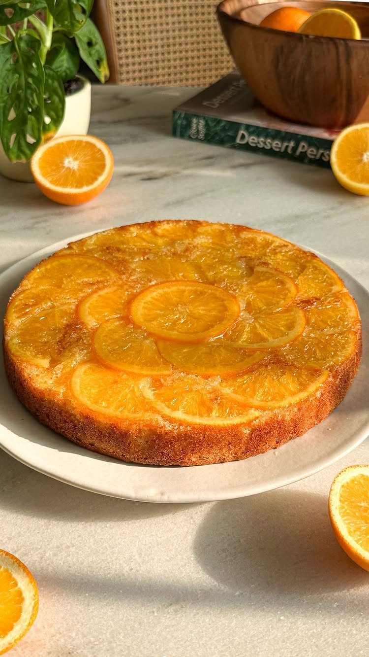 6 Inch Cake Decorating Ideas: 11 Flavors and Finishes to Try 10 Orange cake topped with citrus slices on a white plate with fresh oranges.