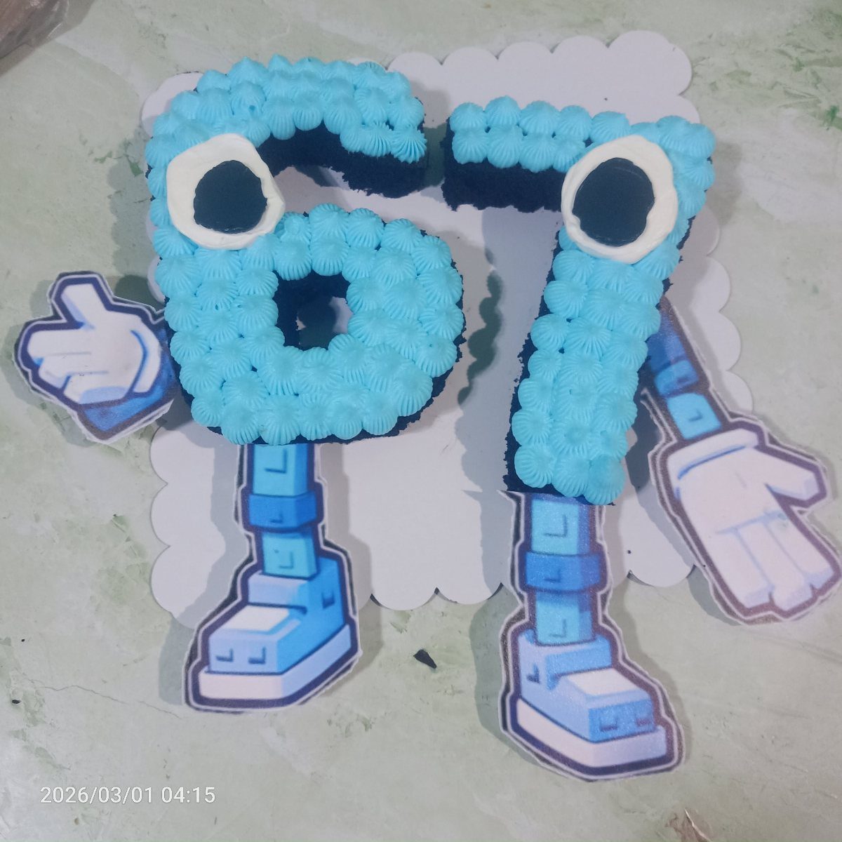67 Cake Ideas for Birthdays: 14 Designs From Drip to Neon 2 Blue piped number 67 cake with cartoon eyes and printed blue limbs.
