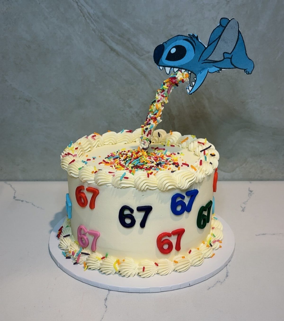 67 Cake Ideas for Birthdays: 14 Designs From Drip to Neon 10 White cake with colorful 67 numbers and a Stitch character sprinkle topper