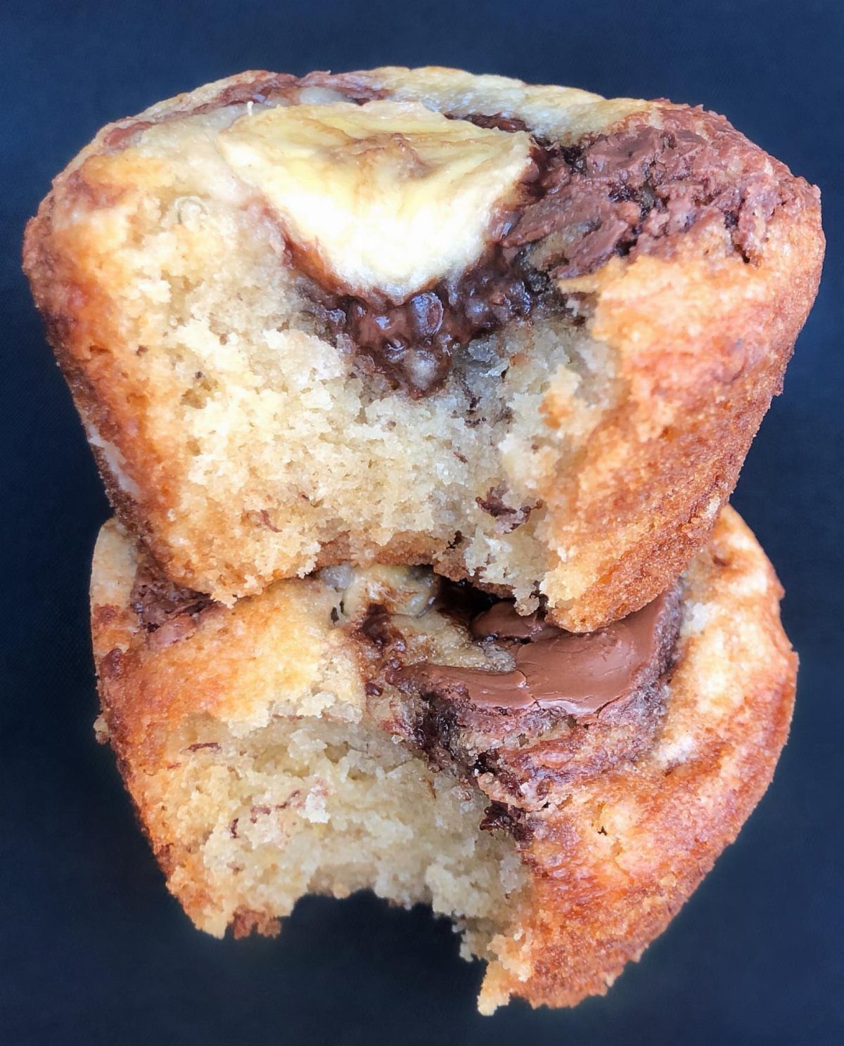 Banana muffins with a banana slice on top and swirls of Nutella inside.