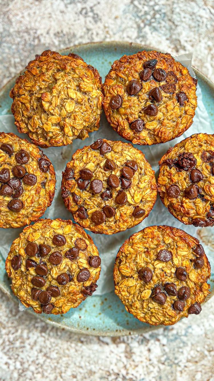 Chocolate chip oat muffins arranged on a light blue ceramic plate.