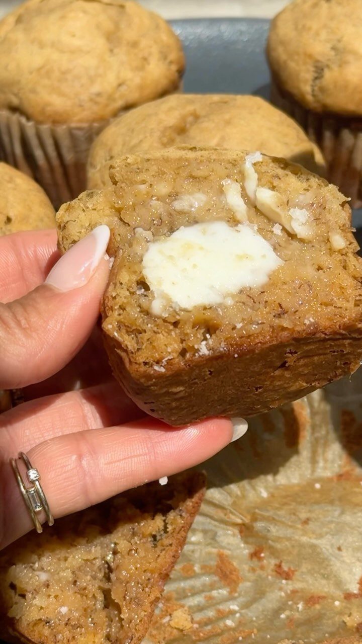 Banana muffin broken open with a pat of melting butter inside.