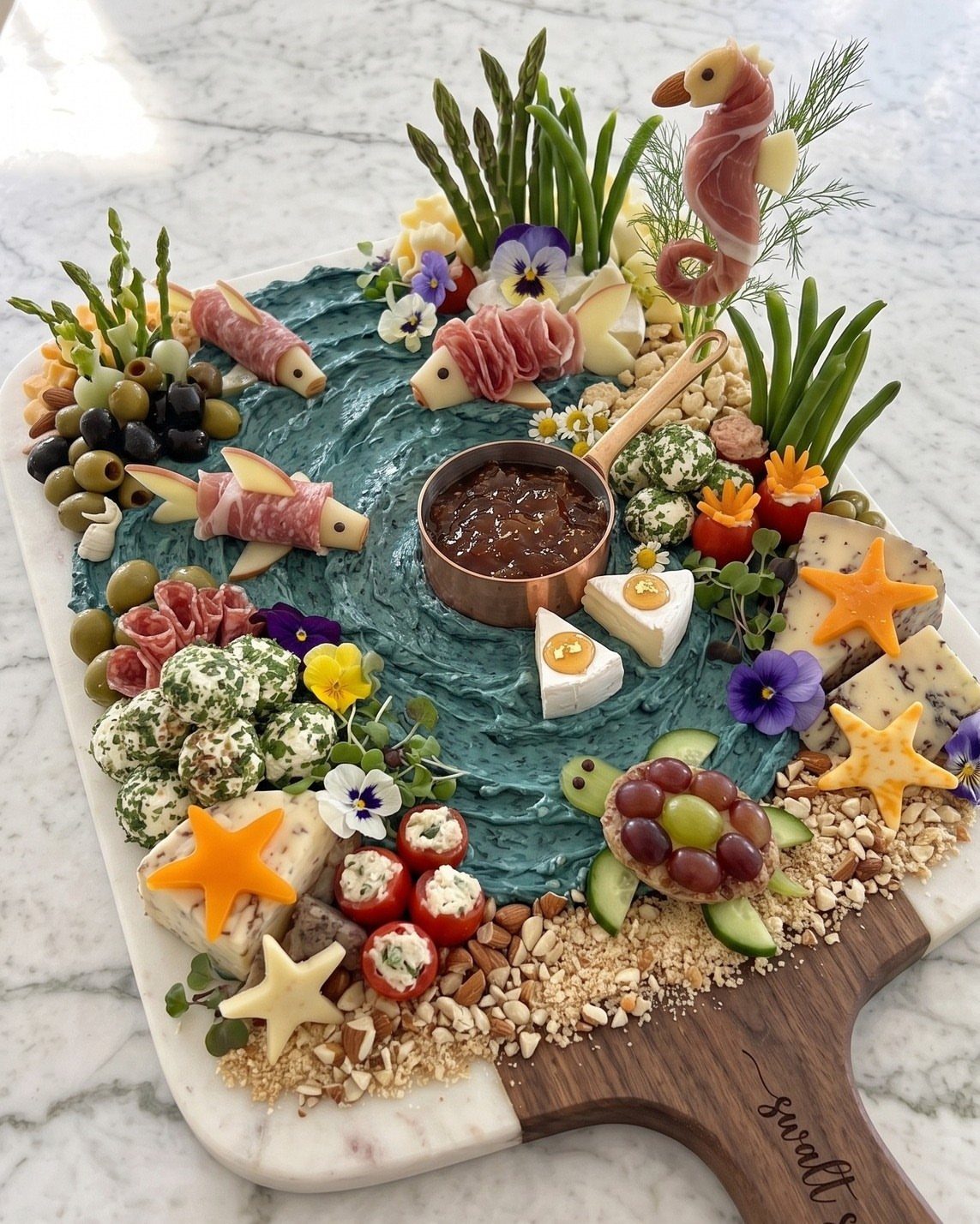 31 Beach Themed Appetizers for Parties, Picnics and Pool Days 25 Ocean themed charcuterie board with blue dip, cheese fish, and a meat seahorse.