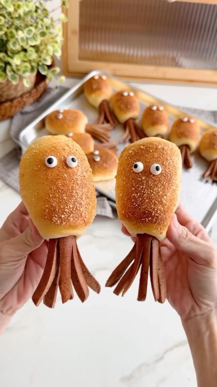 31 Beach Themed Appetizers for Parties, Picnics and Pool Days 10 Octopus hot dogs made with bread rolls and sliced sausages held by hands.