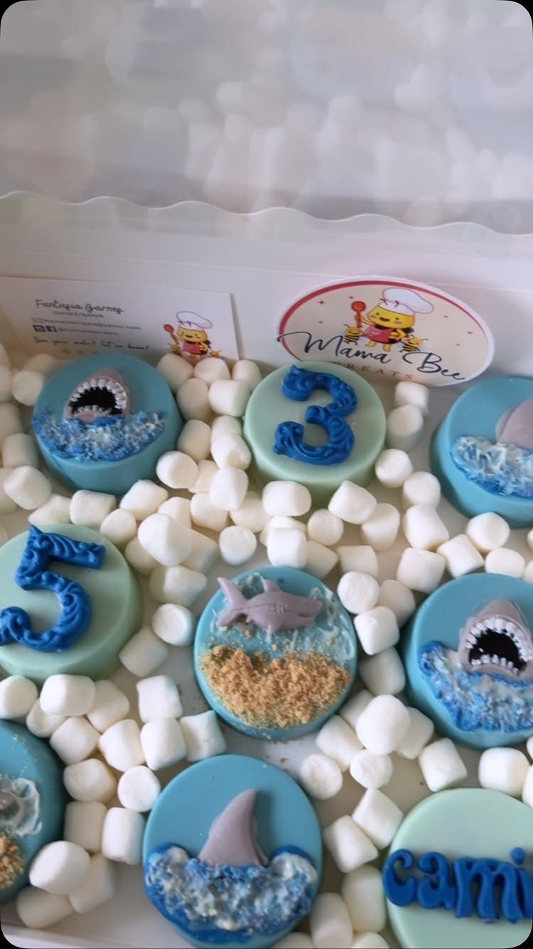 31 Beach Themed Appetizers for Parties, Picnics and Pool Days 28 Shark themed chocolate covered Oreos with blue frosting waves and white marshmallows.