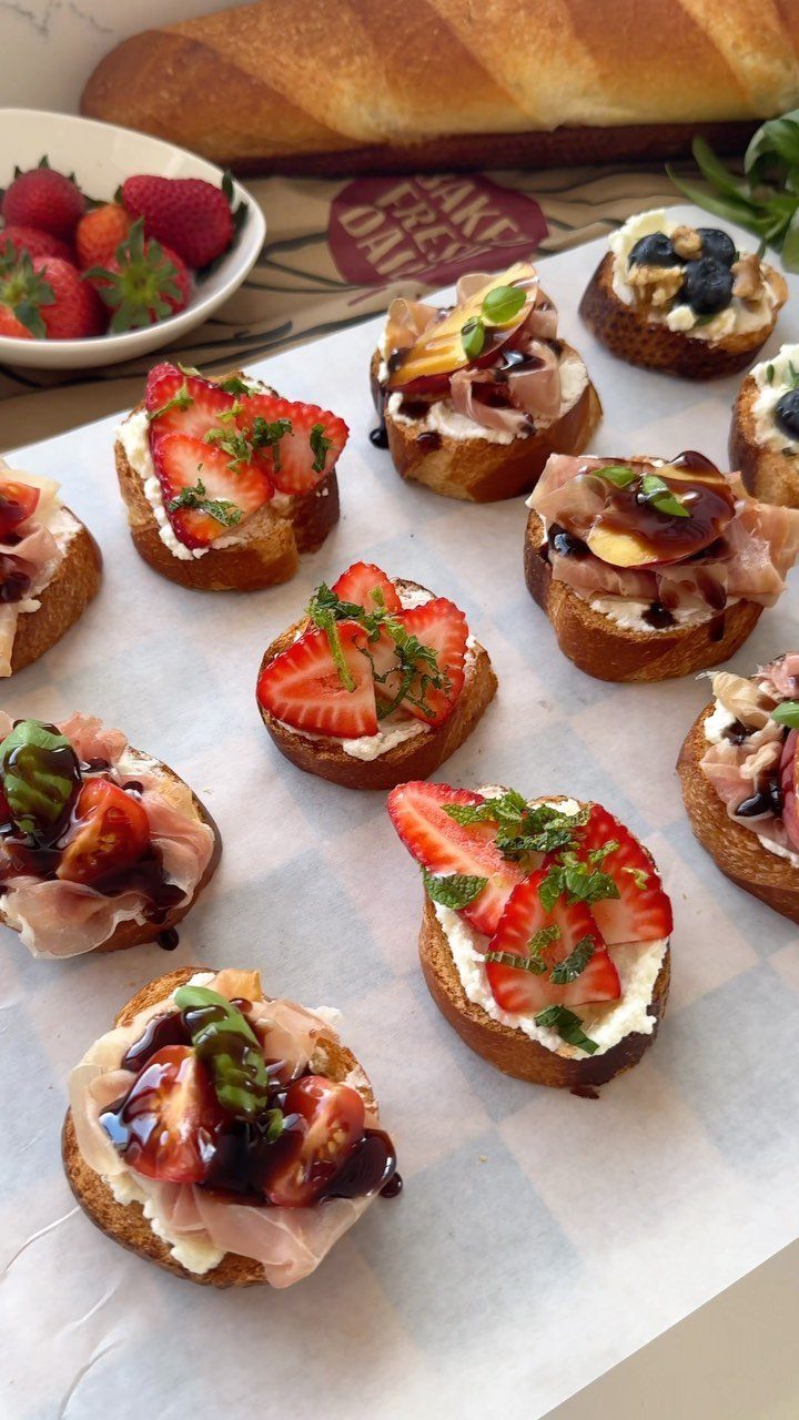 31 Beach Themed Appetizers for Parties, Picnics and Pool Days 18 Assorted bruschetta with strawberries and prosciutto on toasted baguette slices on parchment paper.