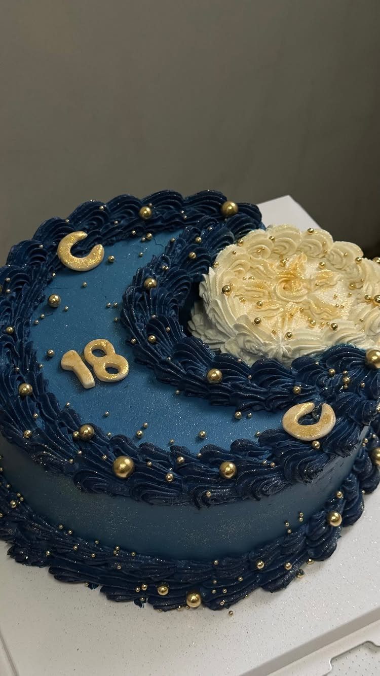 Blue birthday cake with a white frosting moon and gold number 18.
