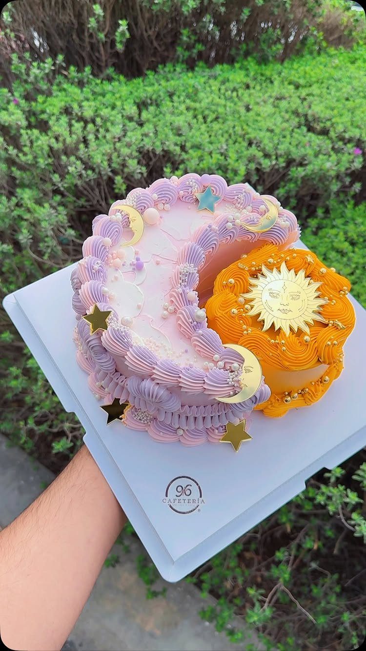 Crescent moon and sun shaped cake with purple and yellow frosting and stars.