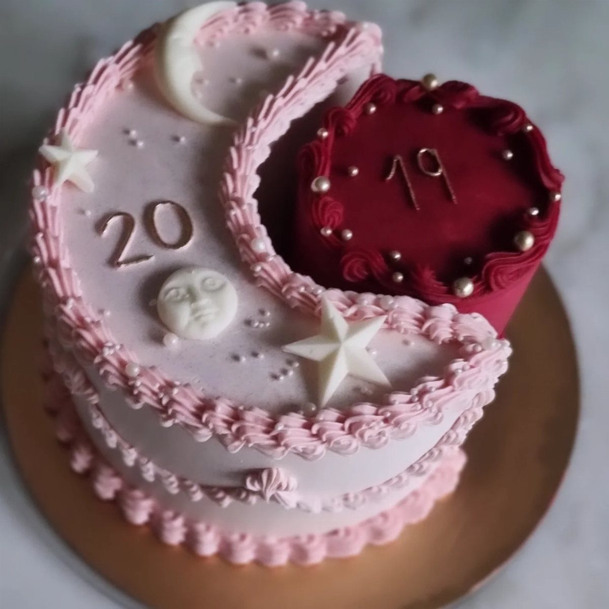 Pink crescent moon and red circular birthday cakes decorated with stars and numbers.