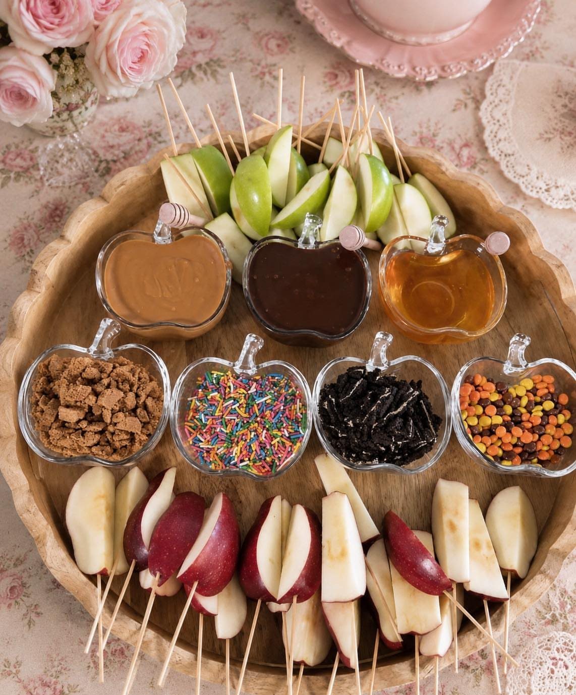 13 Birthday Party Treat Ideas, From Popcorn to Tea Sandwiches 4 Apple slices on skewers with various dips and toppings in apple-shaped bowls.