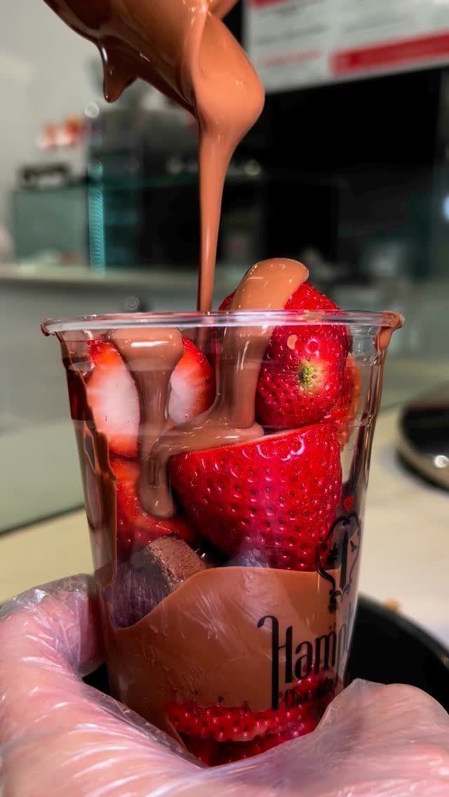 13 Birthday Party Treat Ideas, From Popcorn to Tea Sandwiches 10 Strawberries in a plastic cup with melted chocolate being poured over them.