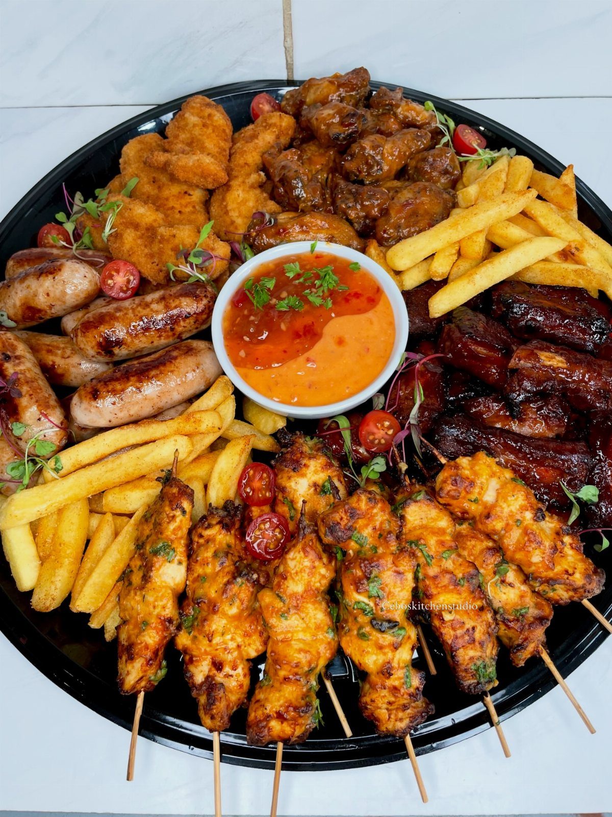 25 Black People Finger Foods 20 Platter of assorted finger foods including wings, fries, sausages, and chicken skewers with dip.
