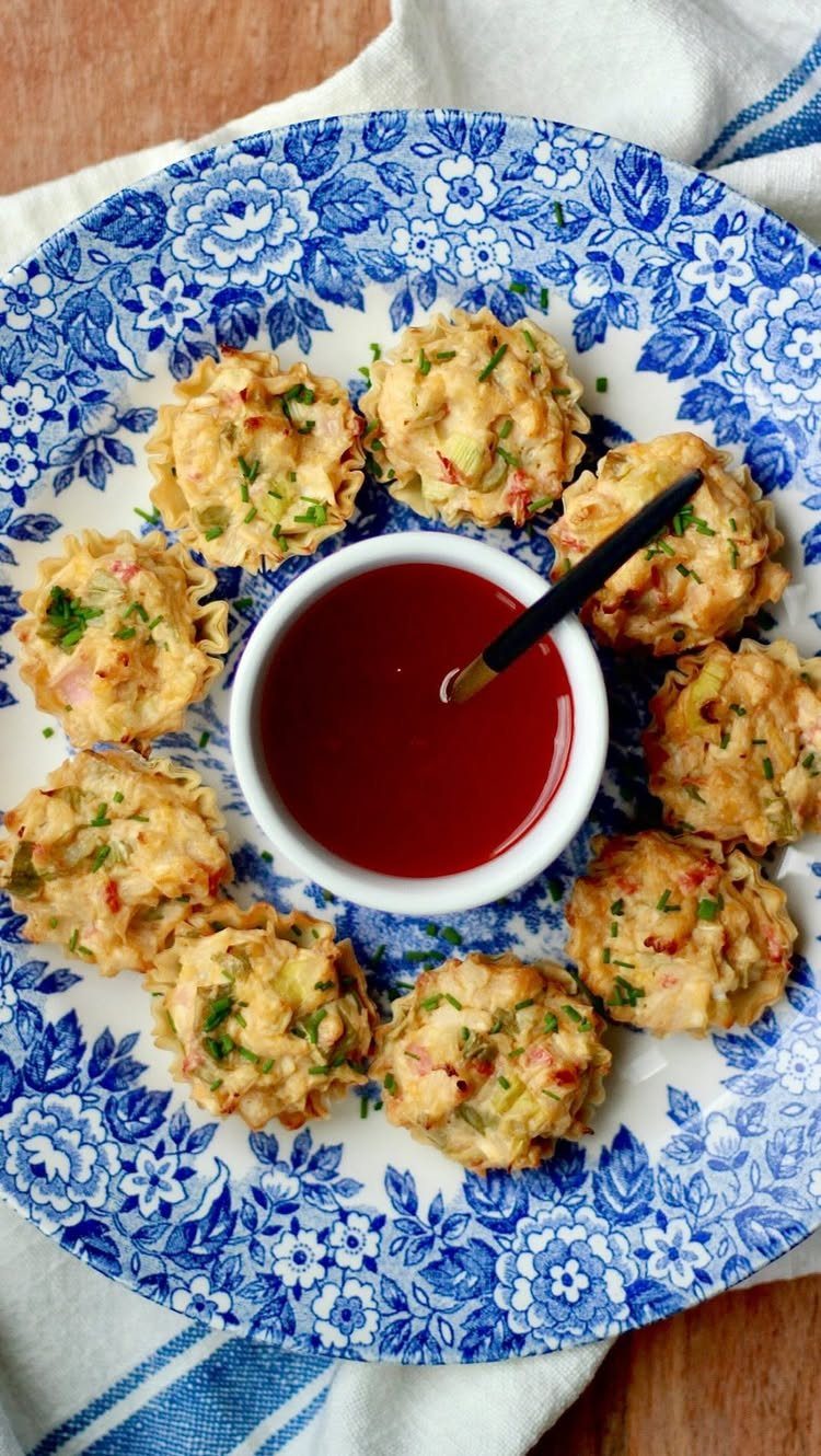 25 Black People Finger Foods 18 Fried seafood cakes on a blue floral plate with red dipping sauce.