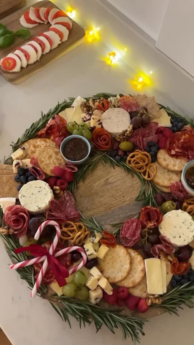Charcuterie board arranged as a wreath with meats, cheeses, and rosemary sprigs.