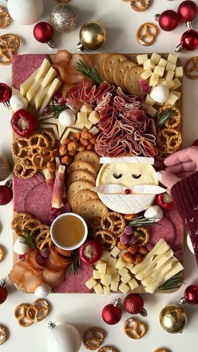 Charcuterie Board Table Ideas: 38 Grazing Tables and Platters 12 Santa Claus shaped charcuterie board with meats and cheeses surrounded by Christmas ornaments.