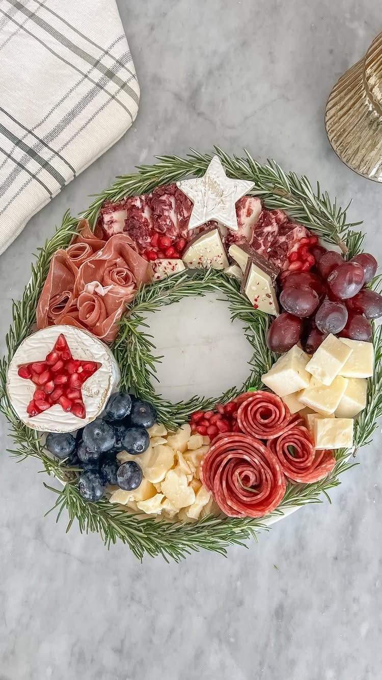 Charcuterie Board Table Ideas: 38 Grazing Tables and Platters 37 Charcuterie wreath with meats, cheeses, and fruits on evergreen branches with star decorations.