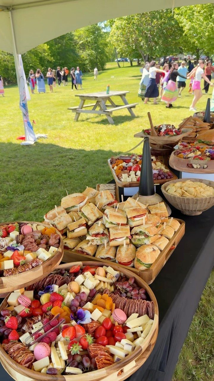Charcuterie Board Table Ideas: 38 Grazing Tables and Platters 2 Large grazing table with sandwiches, cheese, and fruit platters at an outdoor event.