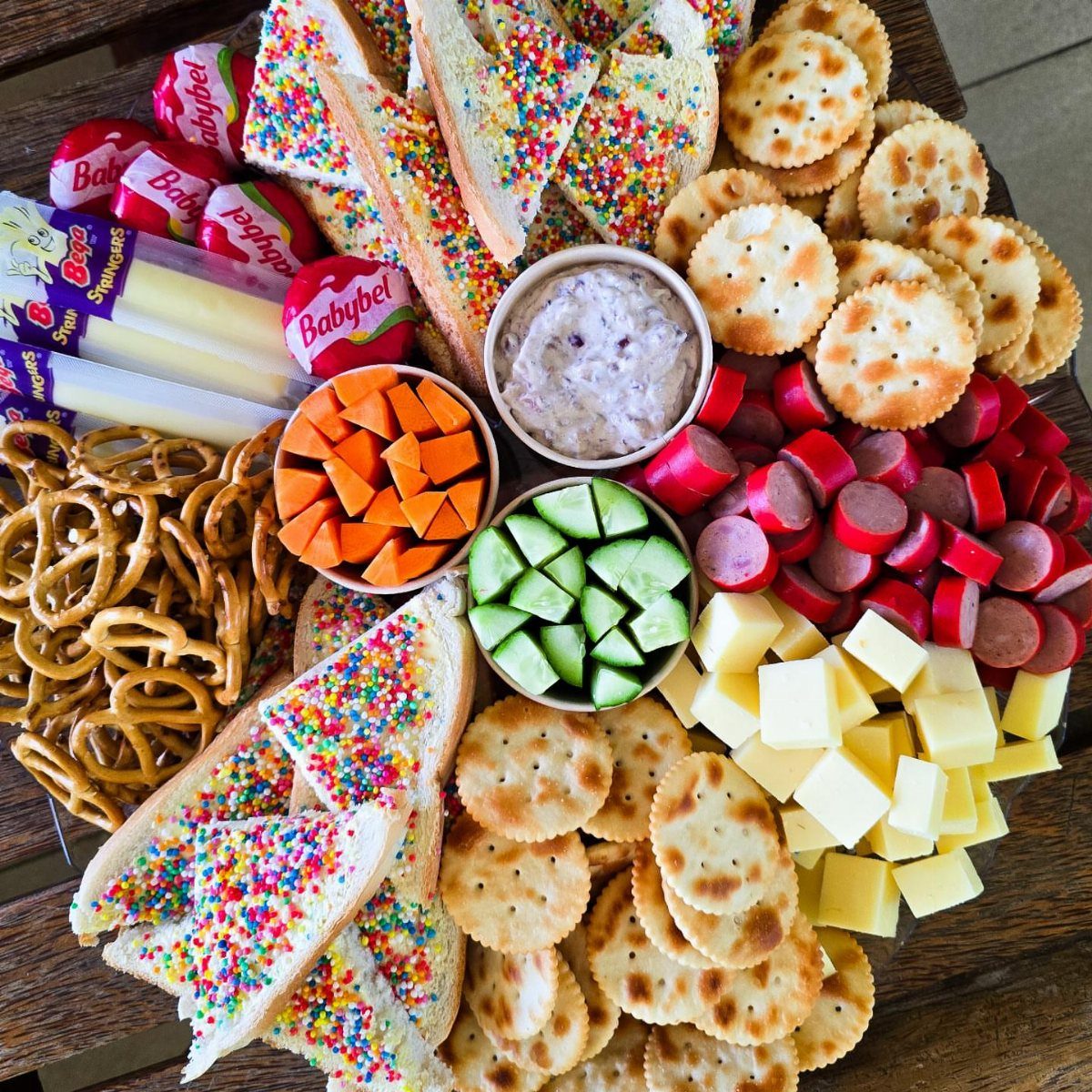 Charcuterie Board Table Ideas: 38 Grazing Tables and Platters 14 Colorful snack board with sprinkle sandwiches, vegetables, cheese, and crackers for a party.