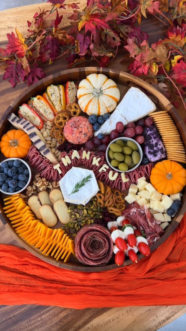 Charcuterie Board Table Ideas: 38 Grazing Tables and Platters 17 Thanksgiving charcuterie board with autumn leaves, small pumpkins, and cheese spelling THANKFUL.