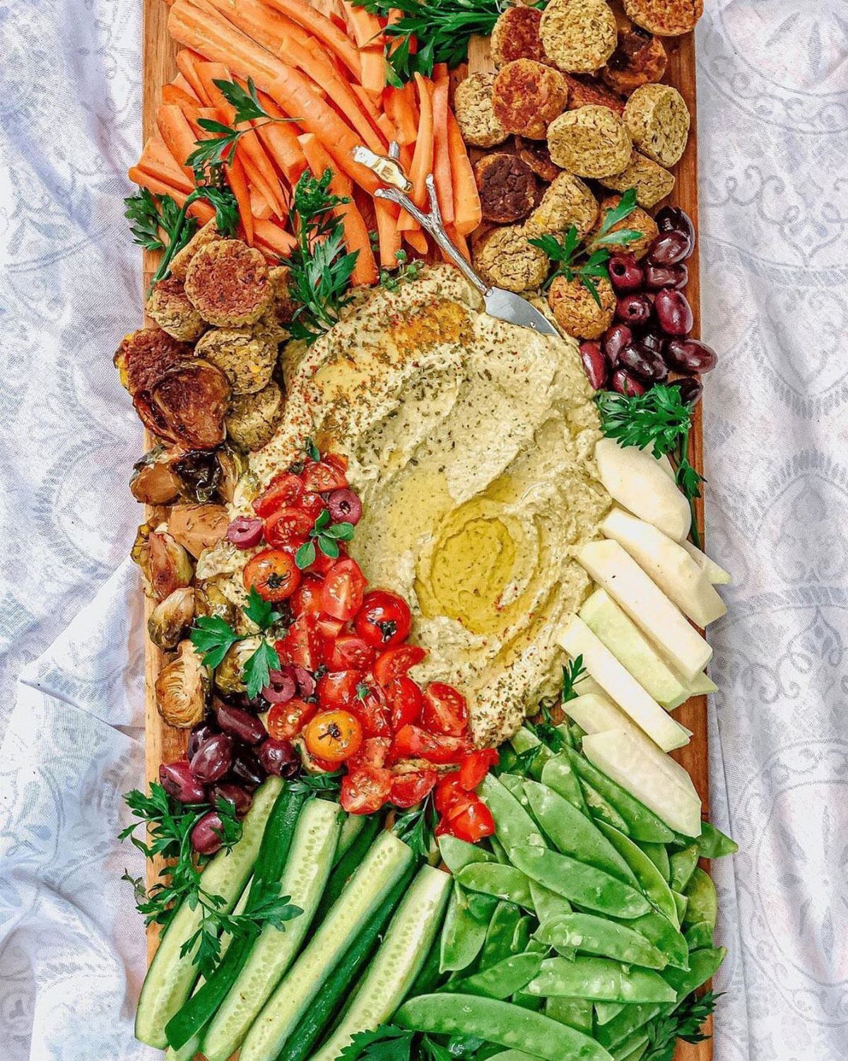 Charcuterie Board Table Ideas: 38 Grazing Tables and Platters 33 Vegan charcuterie board with hummus, fresh vegetables, olives, and plant-based patties on wood.