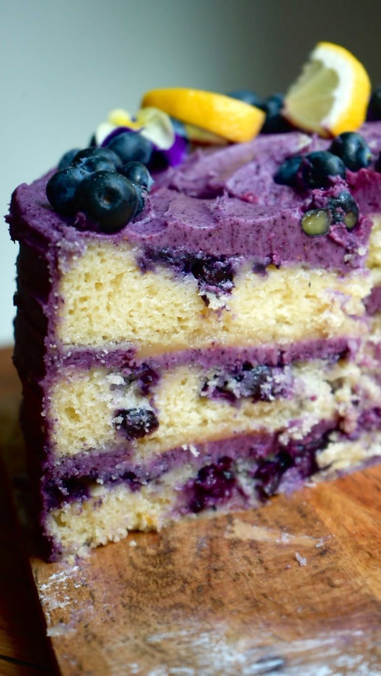 24 Desserts to Make with Blueberries, Cobbler to Cheesecake 6 Layered yellow cake with purple blueberry frosting, fresh blueberries, and lemon slices.