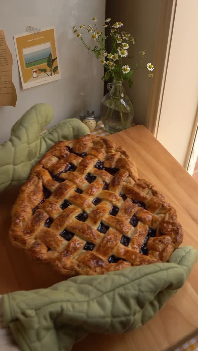 24 Desserts to Make with Blueberries, Cobbler to Cheesecake 14 Lattice-crust blueberry pie held by green oven mitts on a wooden table.