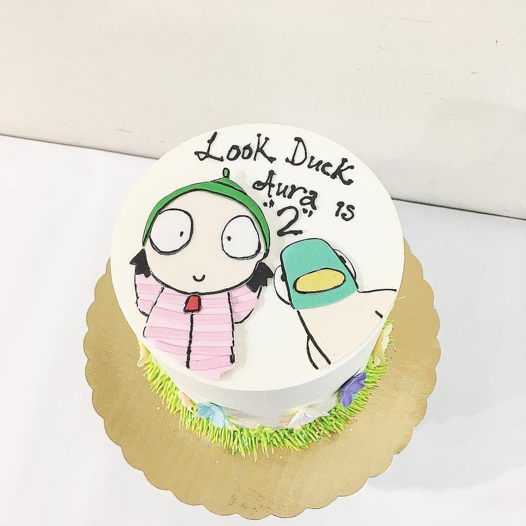 12 Duck Cakes Ideas for Birthdays, From Buttercream to Giant 10 White frosted cake featuring Sarah and Duck characters and birthday text for Aura.