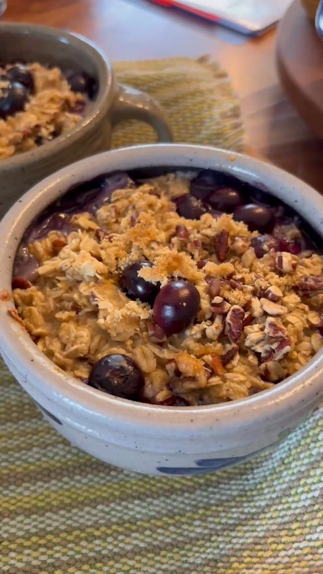 Baked oatmeal with blueberries in small ceramic bowls on a striped cloth.