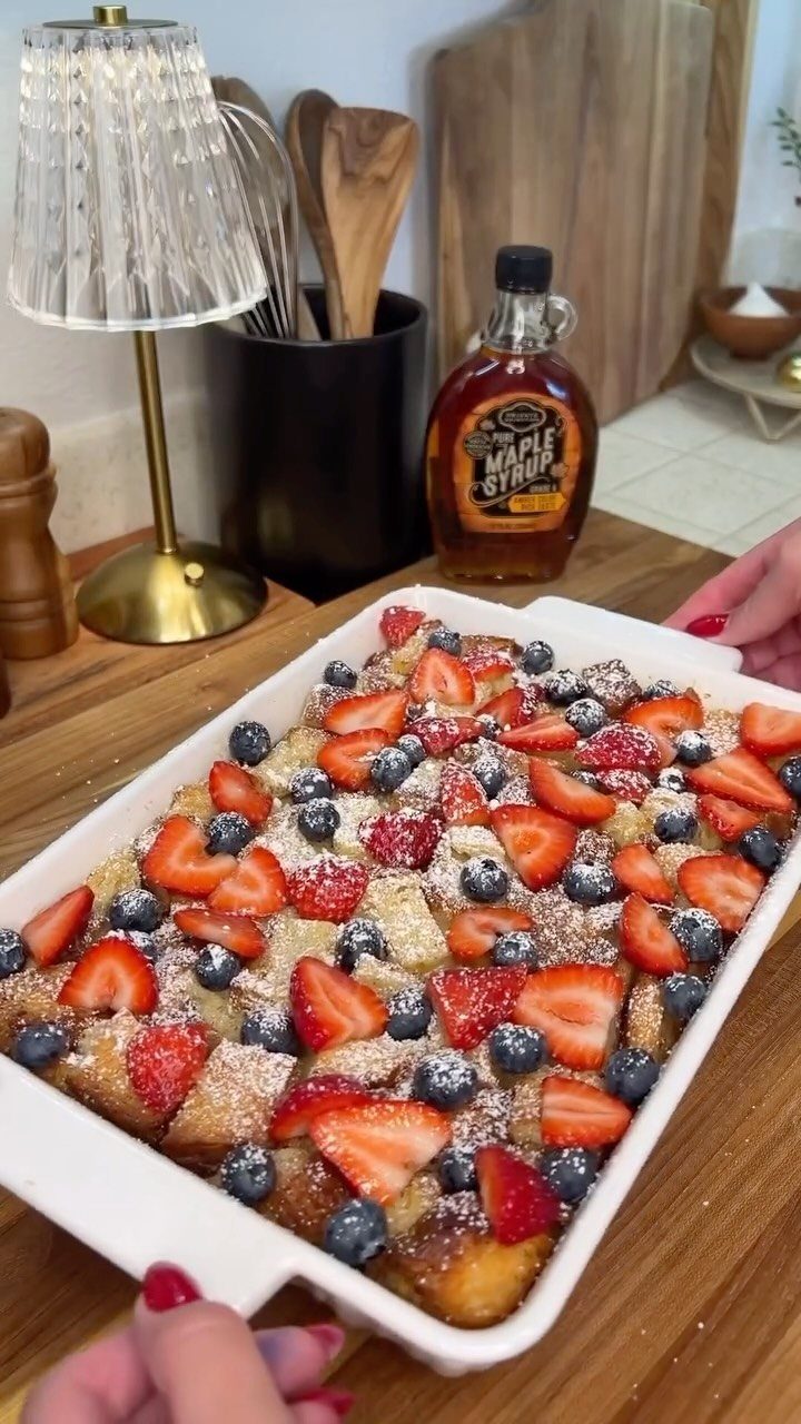 Berry breakfast bake with strawberries and blueberries in a white baking dish.