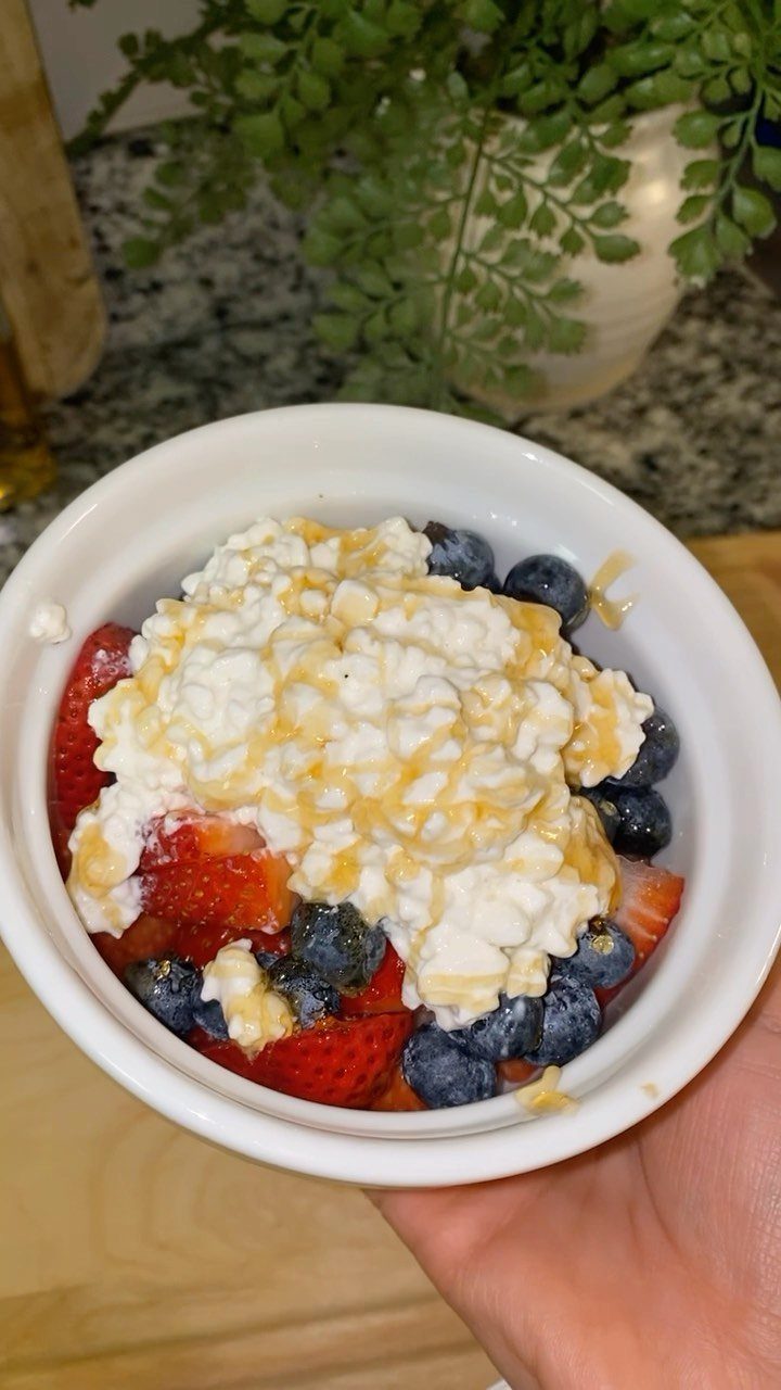 Cottage cheese bowl topped with honey, fresh blueberries, and sliced strawberries.