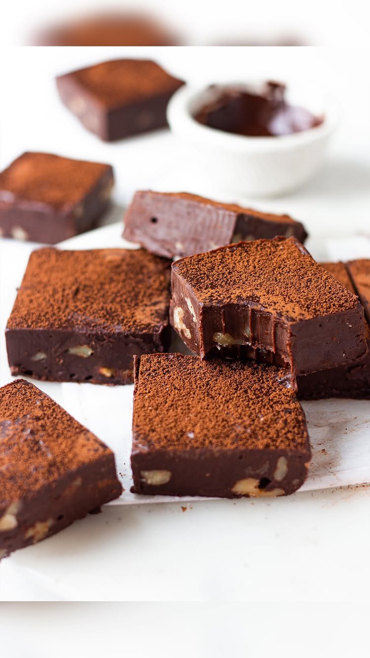 27 Easy Sweet Treats No Bake Ideas, From Fudge to Eton Mess 25 Dark chocolate fudge squares with nuts and cocoa powder on white parchment paper.