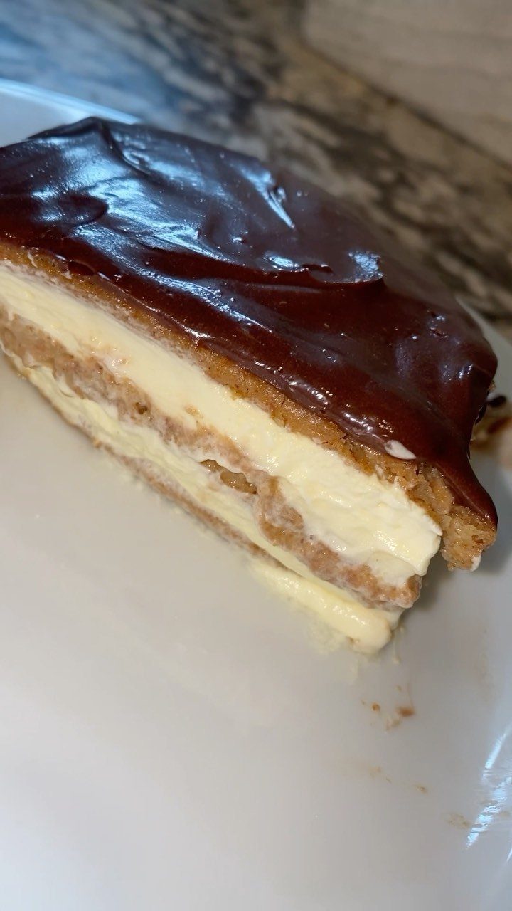 27 Easy Sweet Treats No Bake Ideas, From Fudge to Eton Mess 18 Slice of eclair cake with cream layers and chocolate glaze on white plate