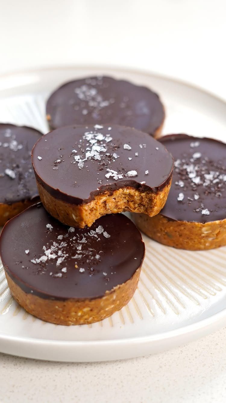 27 Easy Sweet Treats No Bake Ideas, From Fudge to Eton Mess 9 Peanut butter cups with dark chocolate tops and sea salt on a white plate.