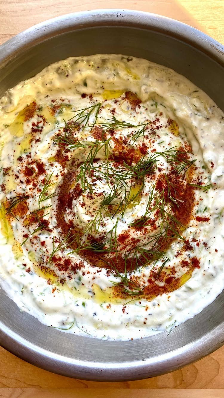 Creamy herb dip in a silver bowl topped with paprika and fresh dill.