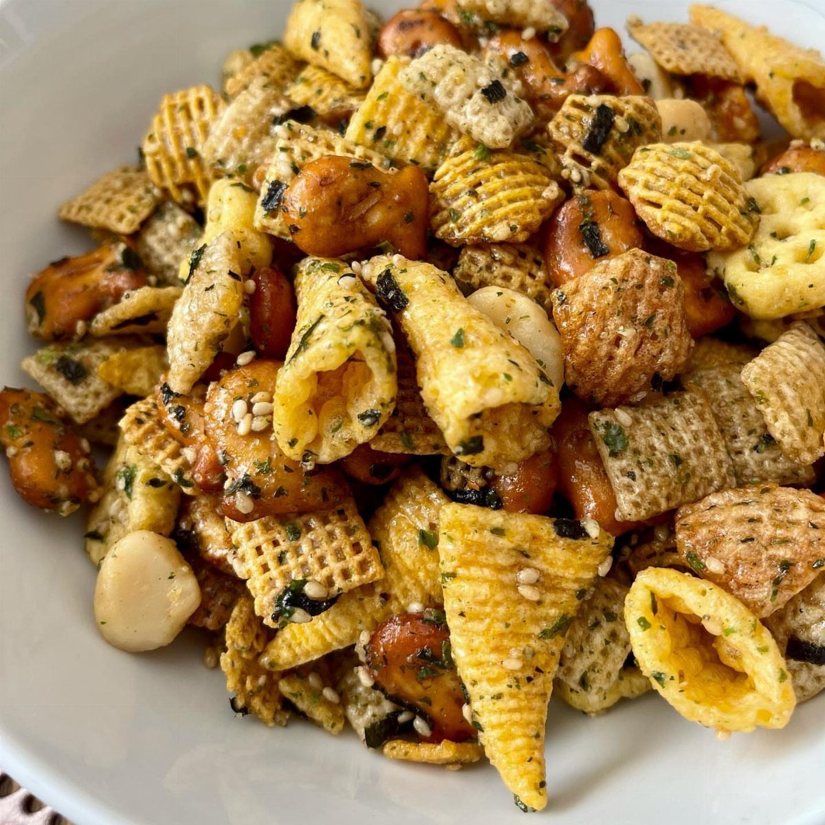 Savory furikake snack mix with ramen noodles and nuts in a white bowl
