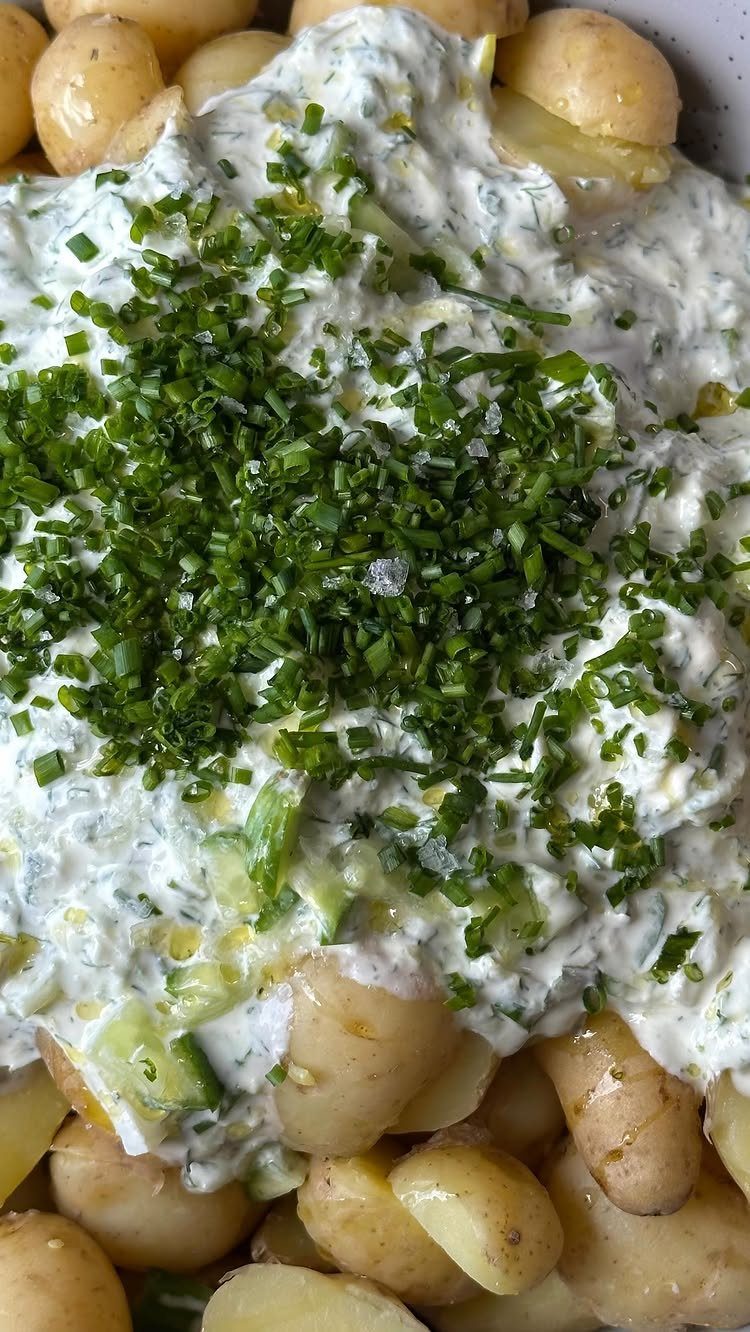 Boiled baby potatoes topped with creamy white dressing and chopped fresh green chives.