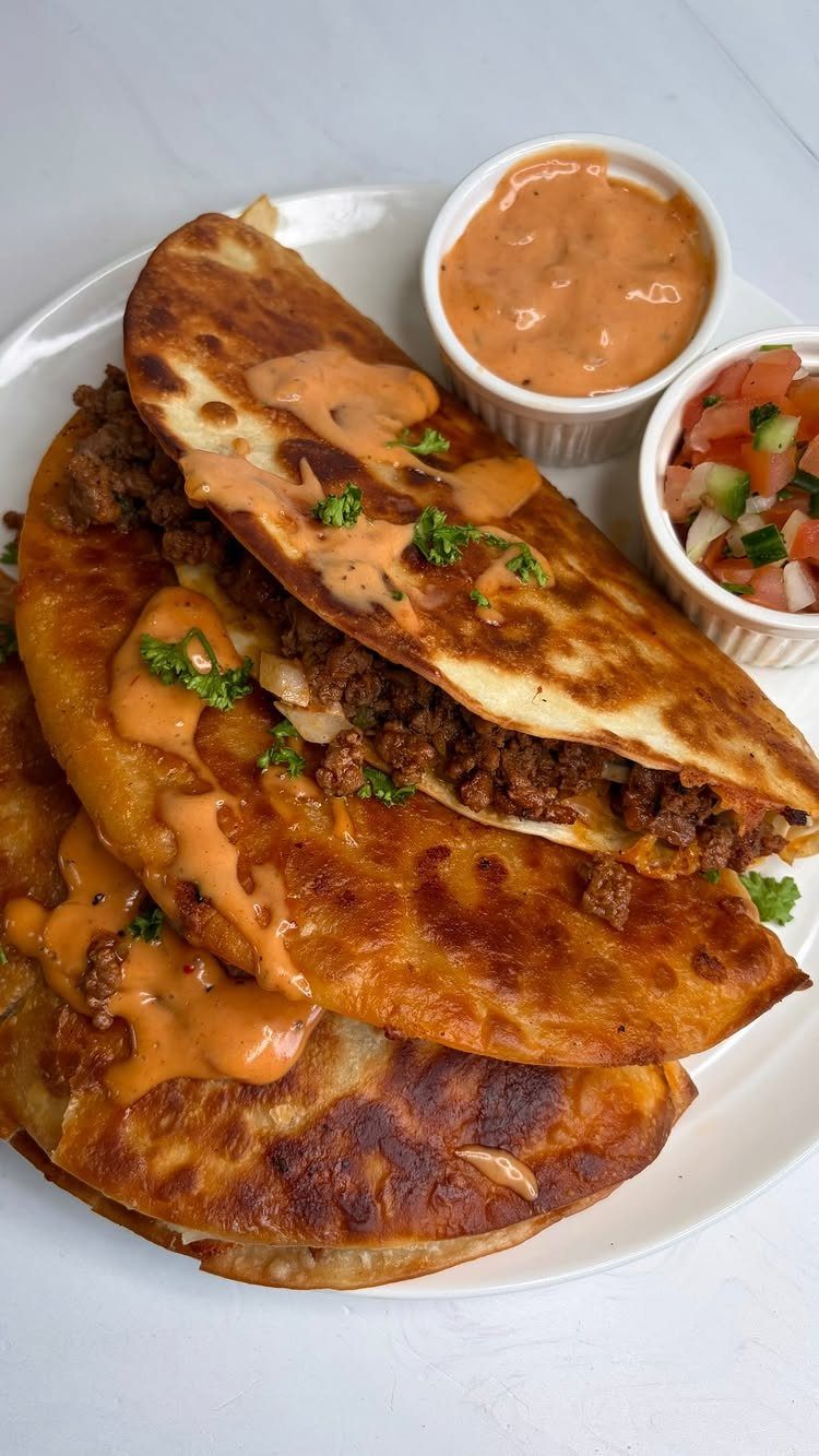 40 Food Lunch Recipes You Can Make in Minutes 32 Beef smash tacos with orange sauce and salsa on a white plate.