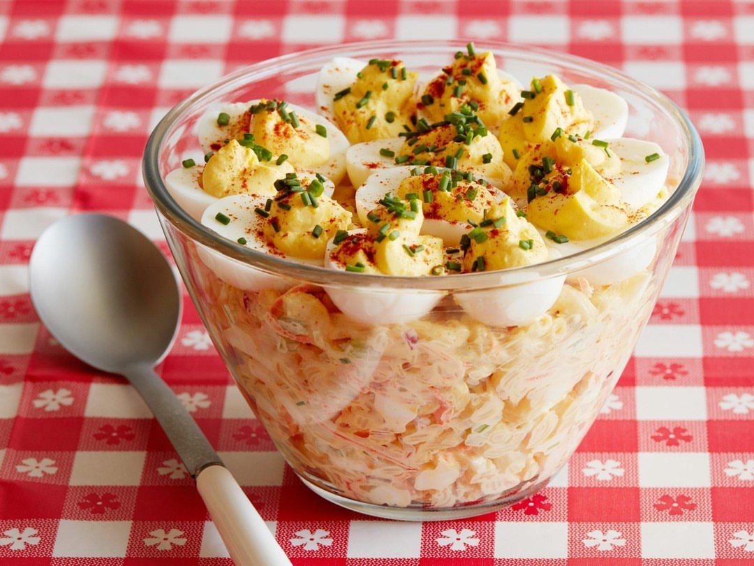 40 Food Lunch Recipes You Can Make in Minutes 12 Deviled egg macaroni salad in a glass bowl on a red checkered tablecloth.
