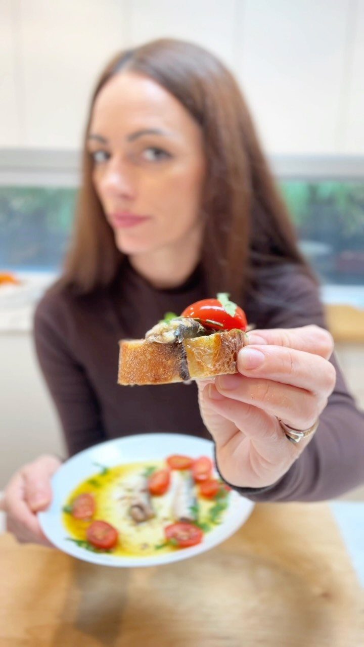 40 Food Lunch Recipes You Can Make in Minutes 4 Sardines on toast with cherry tomatoes held by a woman over a plate.