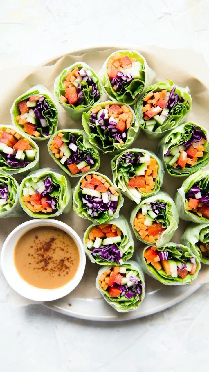 40 Food Lunch Recipes You Can Make in Minutes 26 Fresh vegetable spring rolls with peanut dipping sauce on a white plate.
