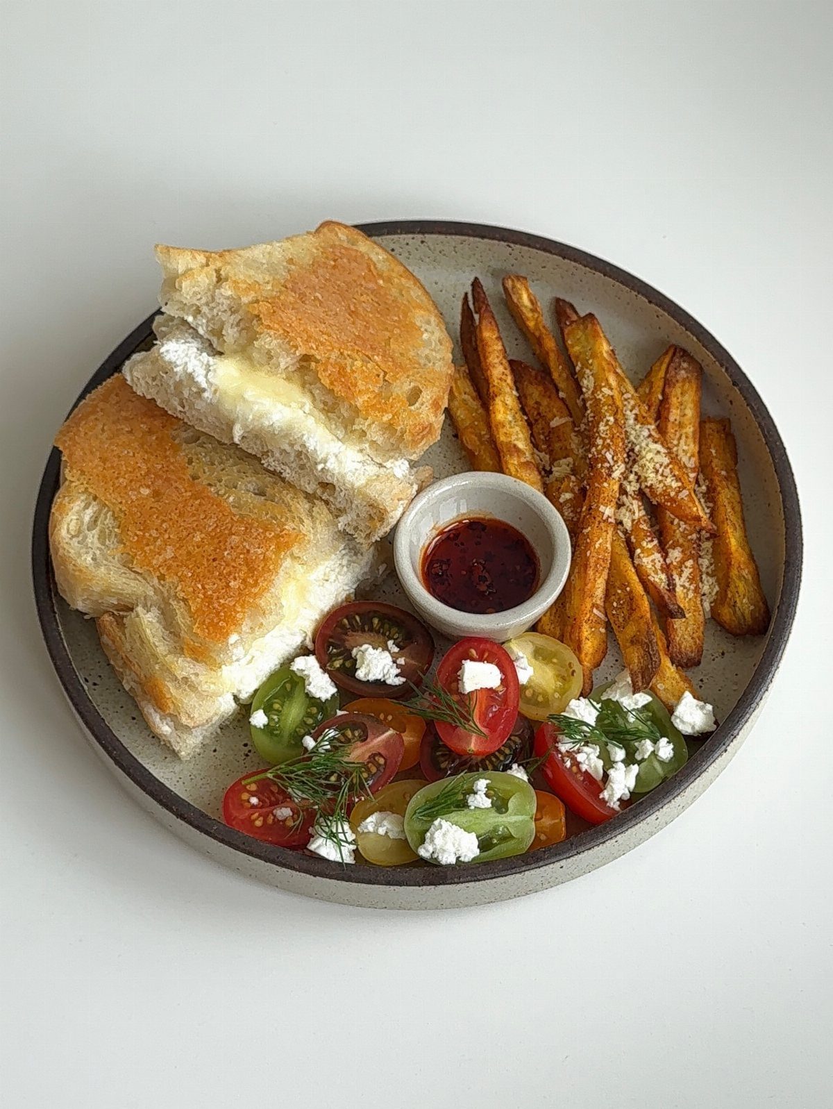 Grilled cheese sandwich with sweet potato fries and a cherry tomato feta salad.