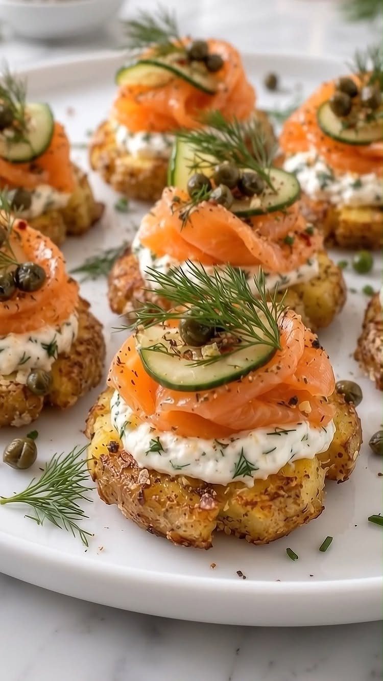 Smoked salmon and cream cheese appetizers on roasted potato rounds with cucumber and dill.