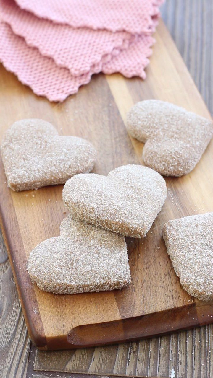 Fun Shaped Cookies: 35 Cut-Out Cookie Recipes to Decorate 5 Heart-shaped cinnamon sugar cookies on a wooden board with a pink napkin.