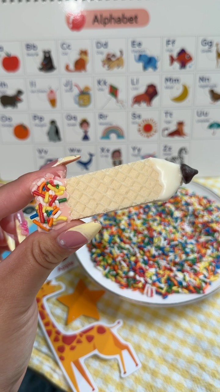 Fun Shaped Cookies: 35 Cut-Out Cookie Recipes to Decorate 24 Pencil shaped cookie with yellow waffle texture and colorful sprinkles held by hand.