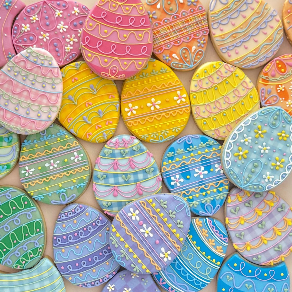 Fun Shaped Cookies: 35 Cut-Out Cookie Recipes to Decorate 18 Egg-shaped sugar cookies decorated with colorful icing patterns for Easter celebration.