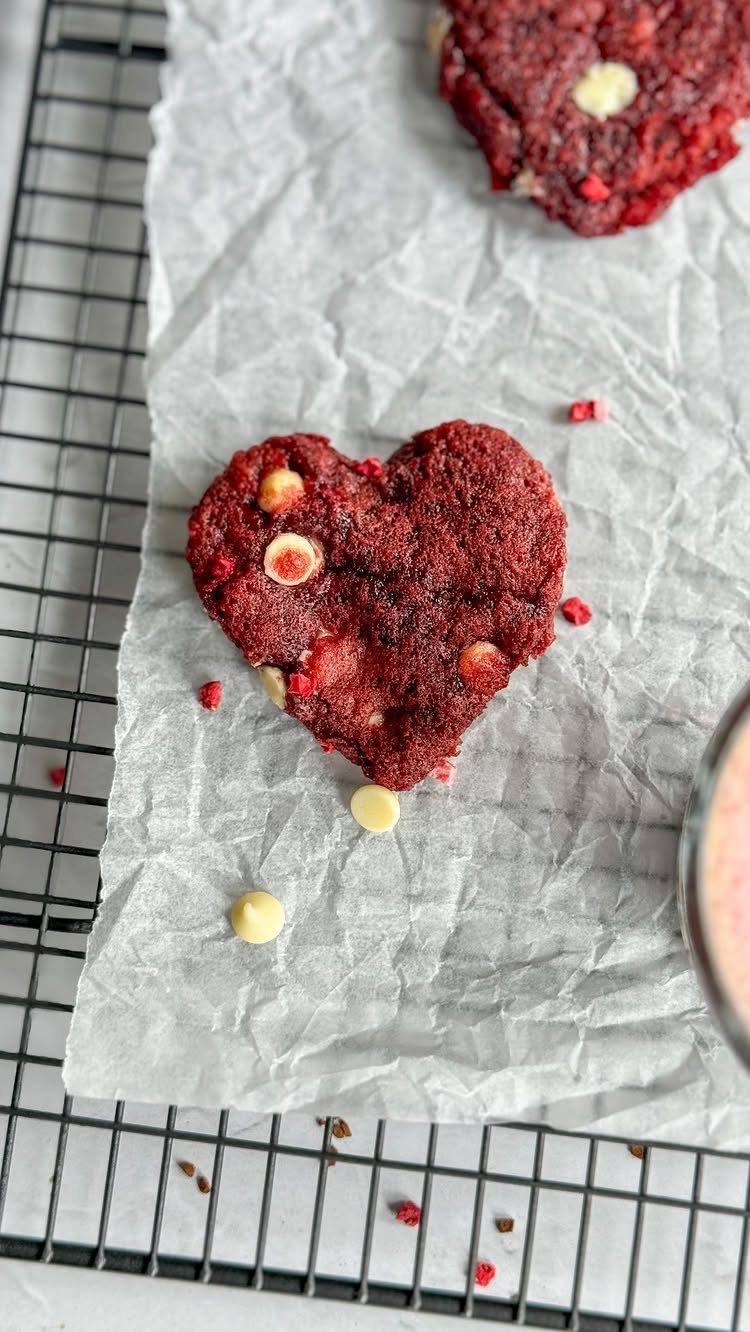 Fun Shaped Cookies: 35 Cut-Out Cookie Recipes to Decorate 11 Heart-shaped red velvet cookie with white chocolate chips on white parchment paper.