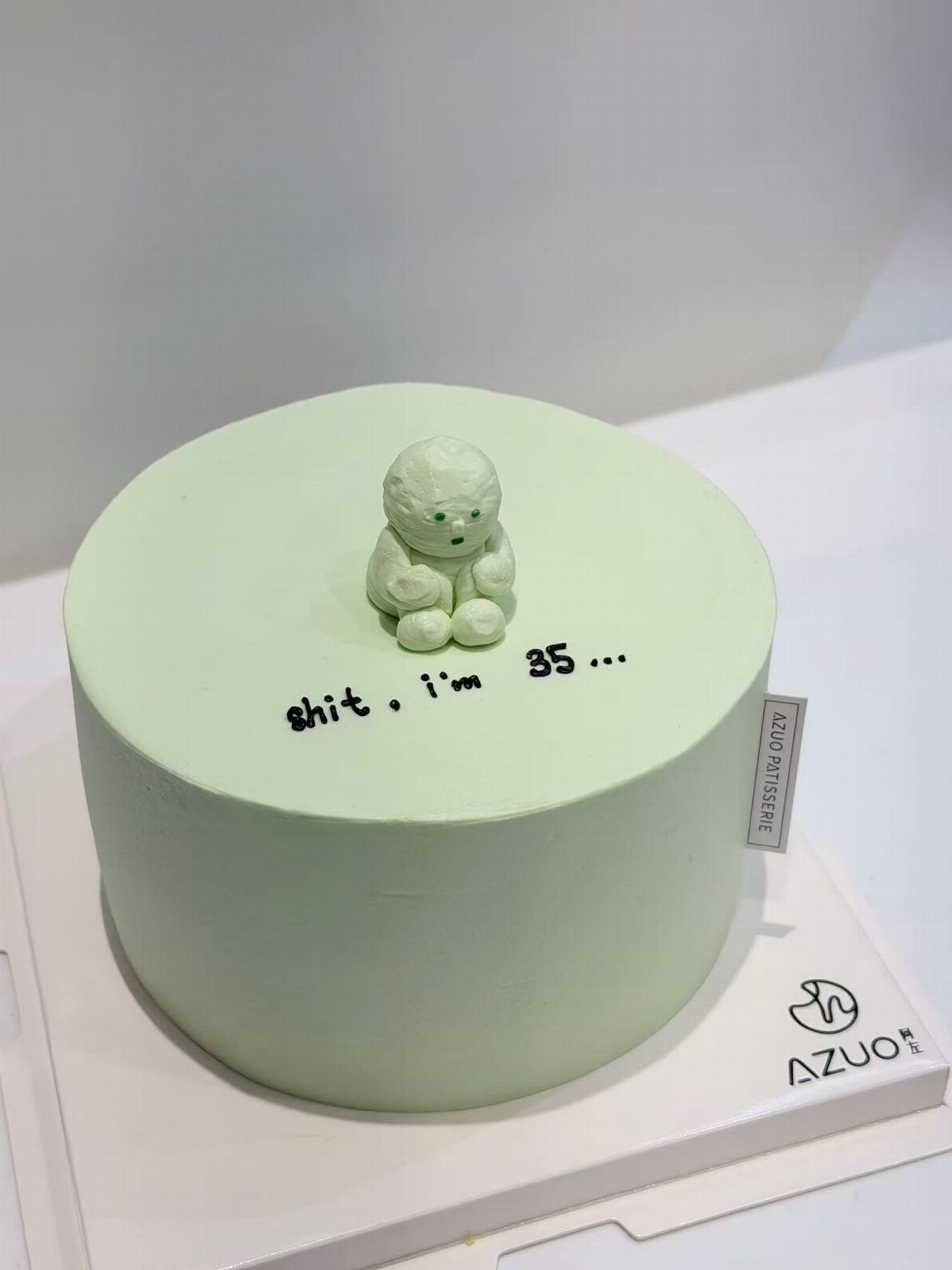 24 Funny Cakes Ideas for Birthdays, From Pizza to Poop Emoji 11 Light green cake with a small fondant figure and text saying shit i'm 35