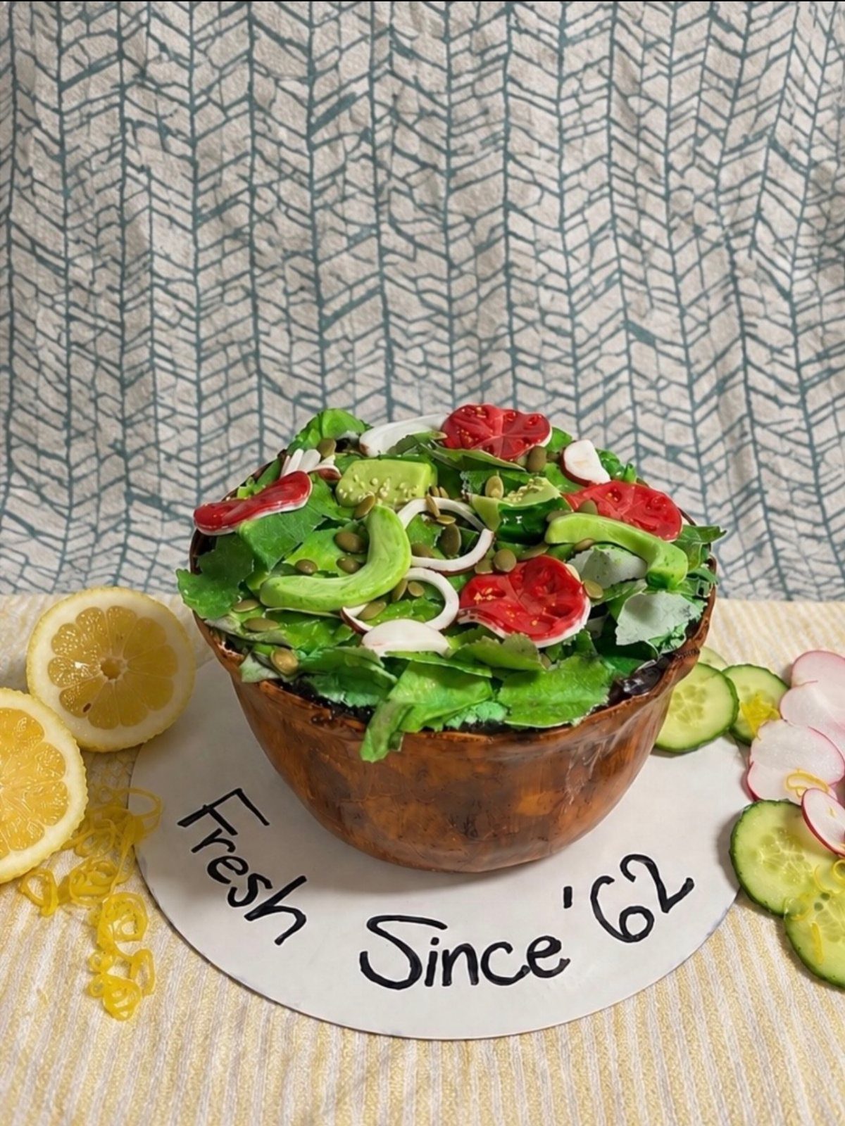 24 Funny Cakes Ideas for Birthdays, From Pizza to Poop Emoji 3 Salad cake with green frosting leaves and red tomato slices in a brown bowl.